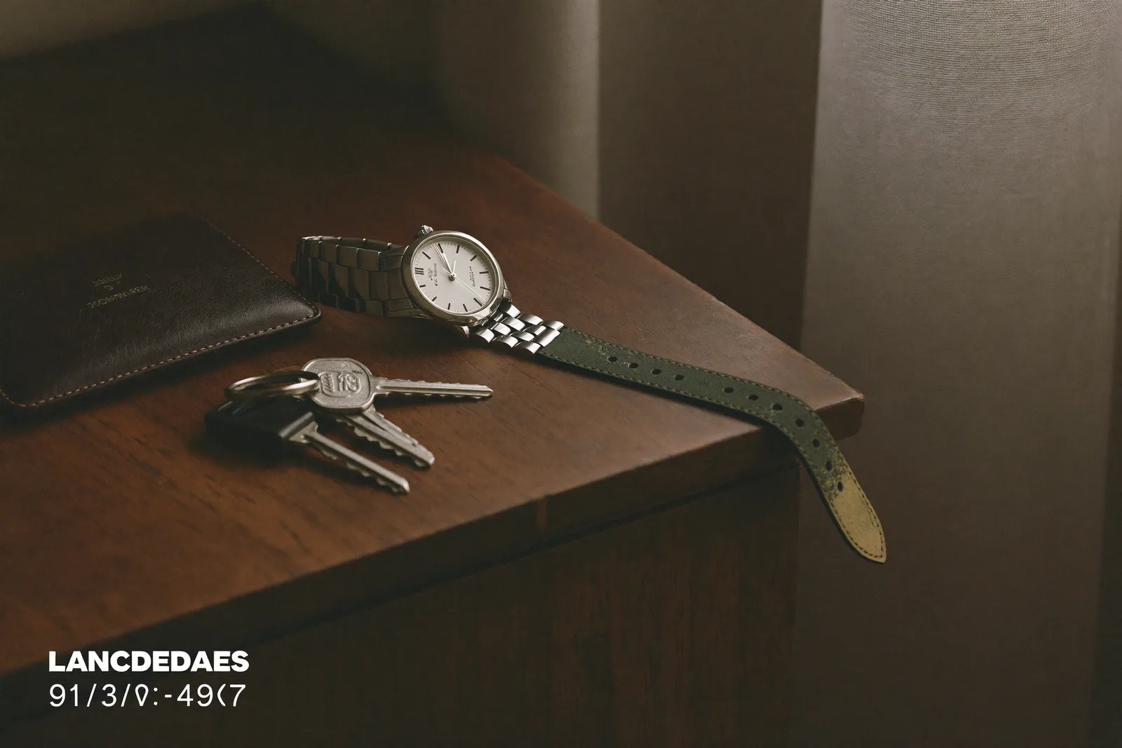 A single steel watch on a nightstand beside car keys and a wallet in dawn light
