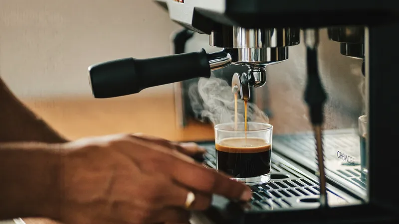 A prosumer espresso machine pulling a shot through a bottomless portafilter in morning light